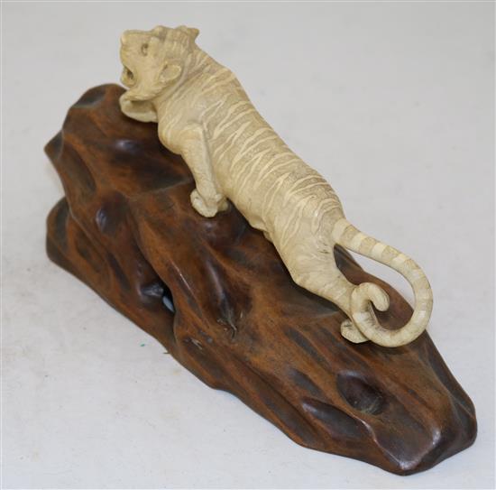 A Japanese ivory figure of a prowling tiger, Meiji period, length 26cm incl. carved wood stand